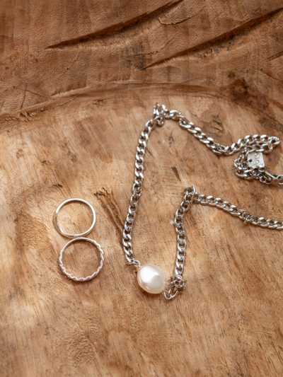 Collier Ollie 1 en lifestyle à Tulum - chaîne mailles en acier inoxydable avec perle baroque blanche + bagues argent été 2024 Kara Bijoux